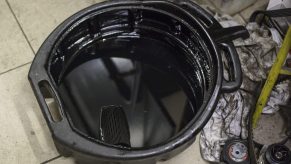 A container with drained car oil after oil change pictured at the car service