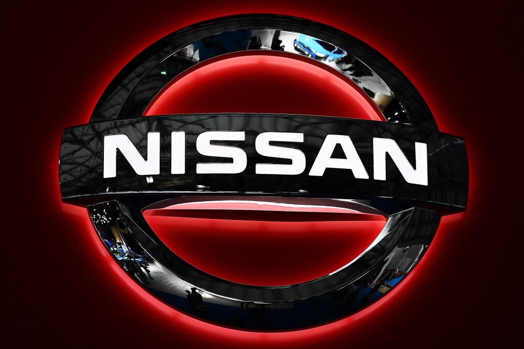 A black Nissan logo backlit in red
