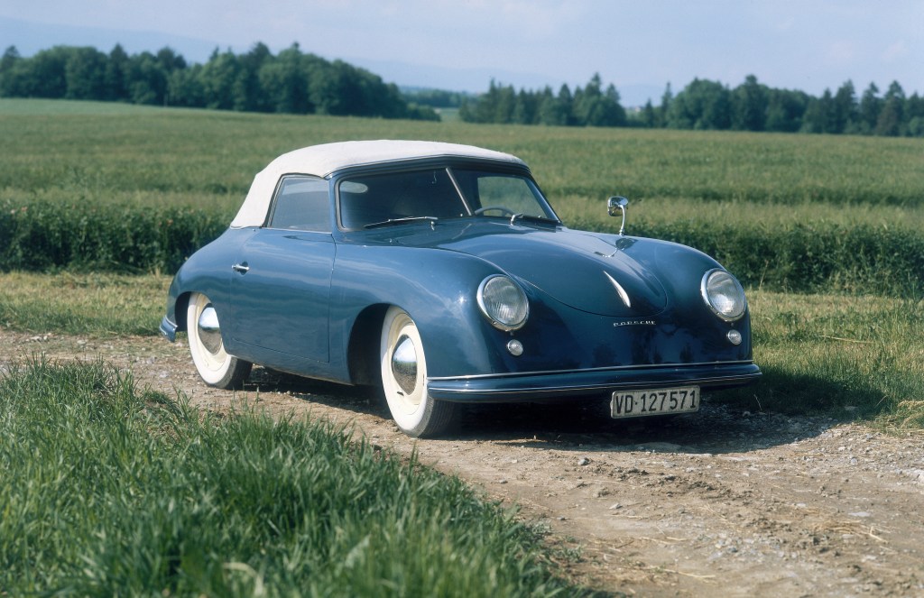 1951 Porsche 356 in blue with a white soft top parked in a field 