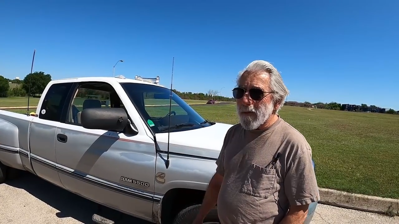 a 1997 Dodge Ram 3500 with its owner standing in front of it