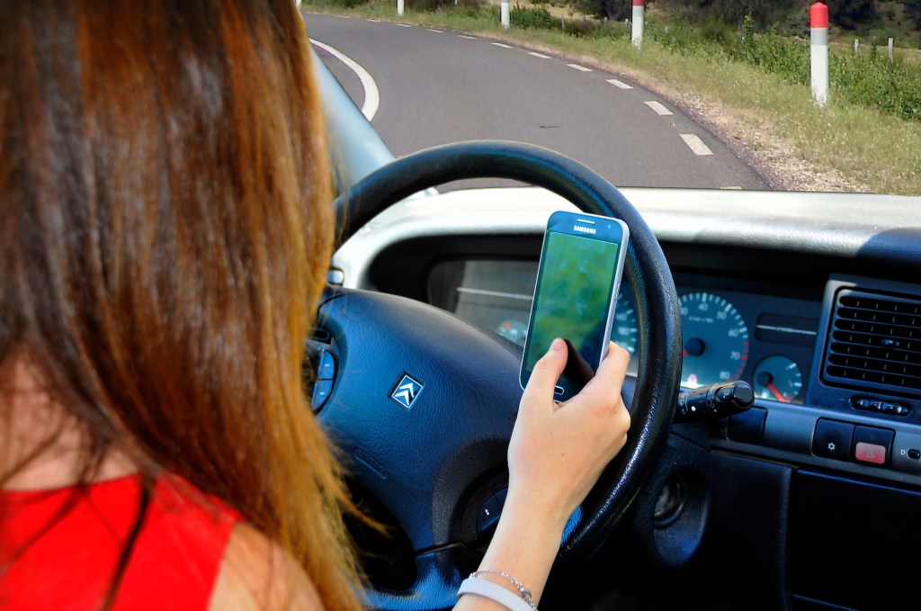 A teen driver using a phone at the wheel