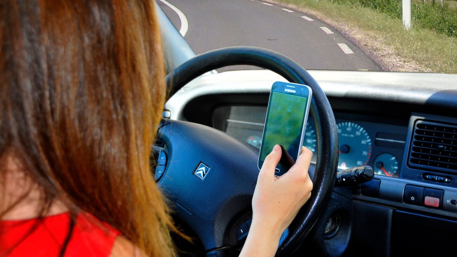 A teen driver using a phone at the wheel