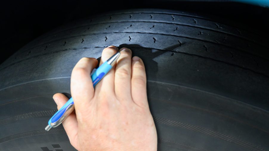 A man checks the tread on tires