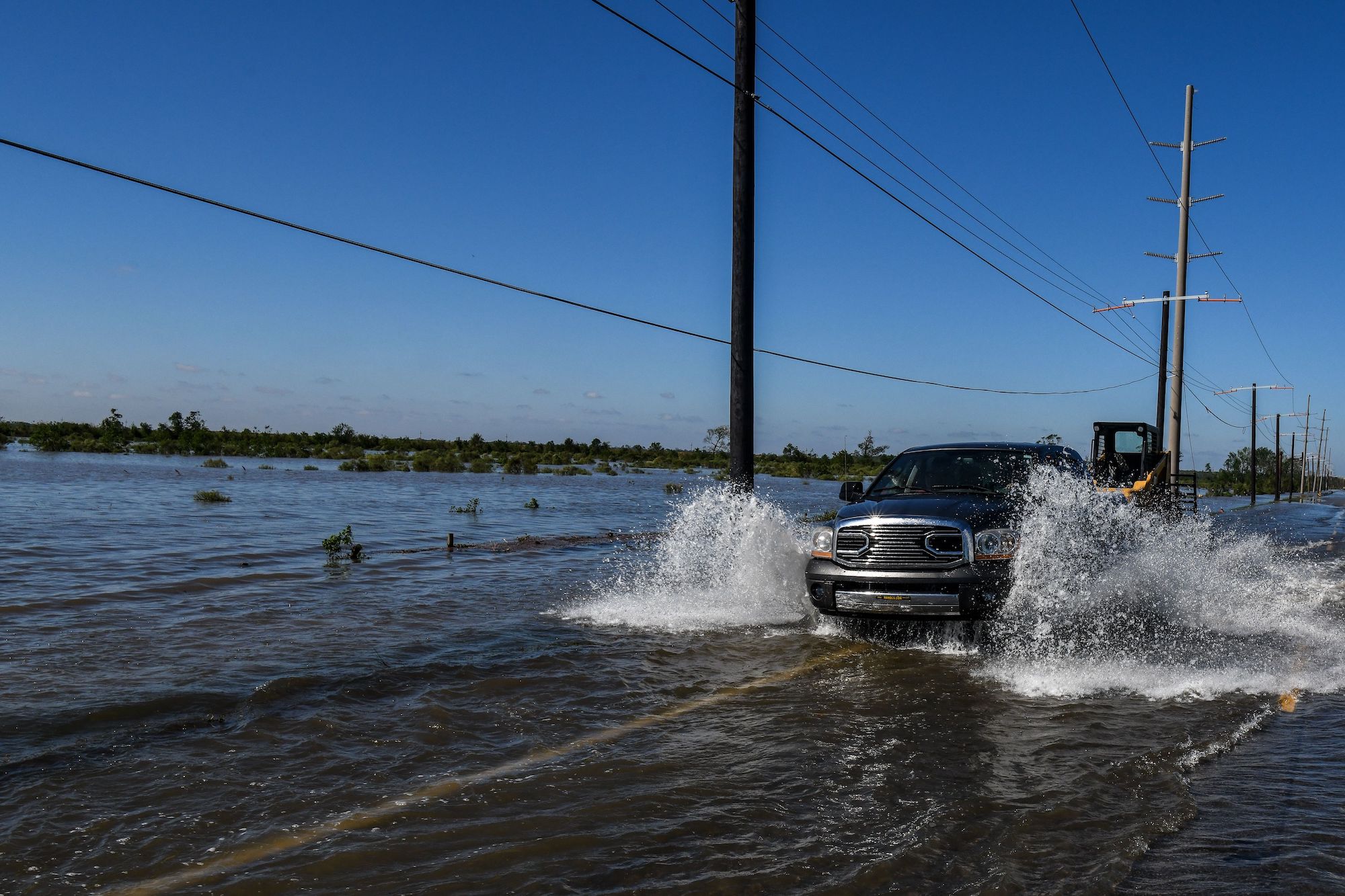 Cars drive through flood water after Hurricane Delta passed through the area on October 10, 2020, near Lake Charles, Louisiana
