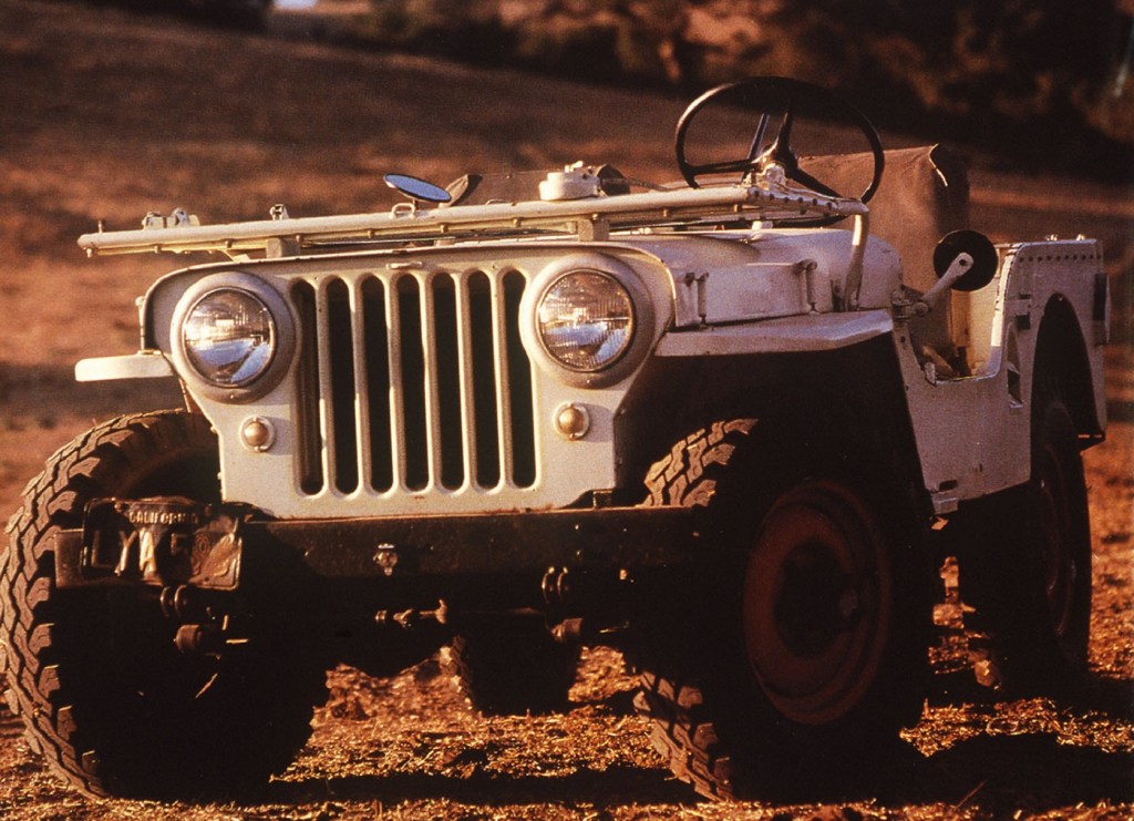 A white 1945 Jeep CJ-2A in a field with its windshield folded down