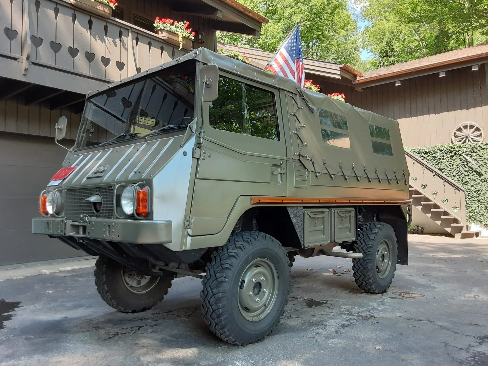 Bob Lutz's olive-green 1973 Steyr-Puch Pinzgauer 710M in front of a brown house