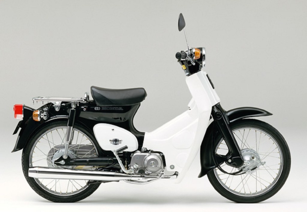 A side view of a black-and-white 1991 Honda Super Cub C50