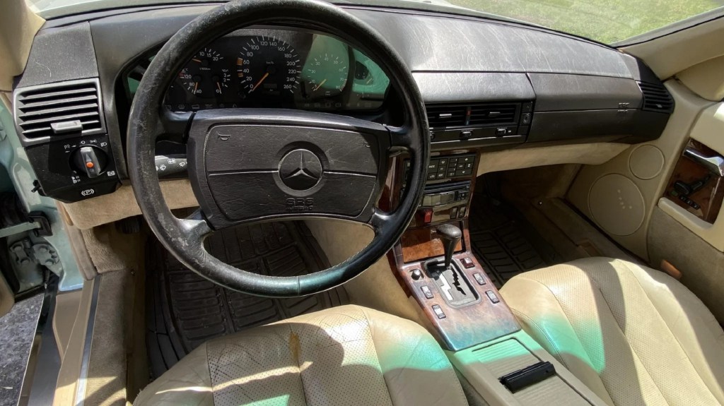 The tan-leather seats and wood-lined black dashboard of a 1991 Mercedes-Benz 300 SL