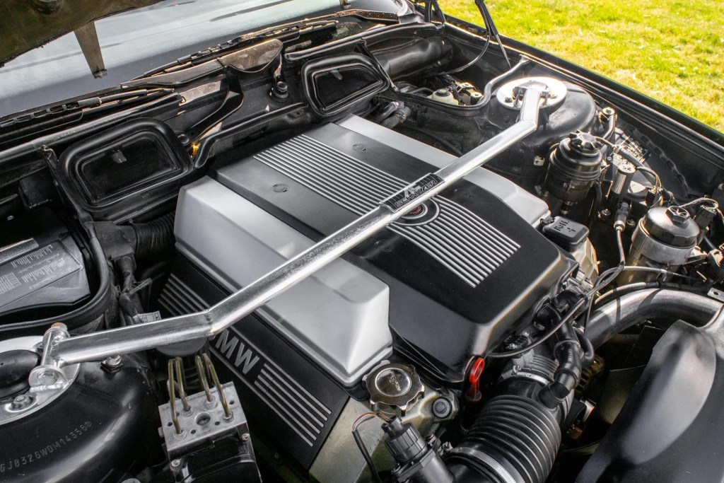 The engine bay of a black 1998 BMW 740iL showing the M62 4.4-liter V8