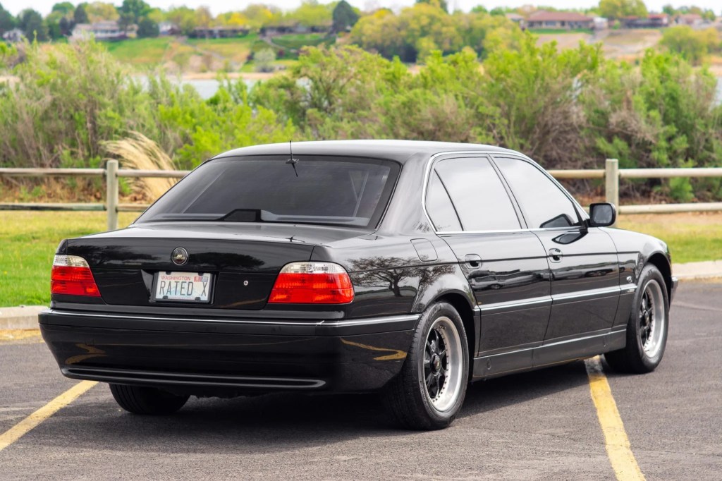 The rear 3/4 view of a black 1998 BMW 740iL in a parking lot