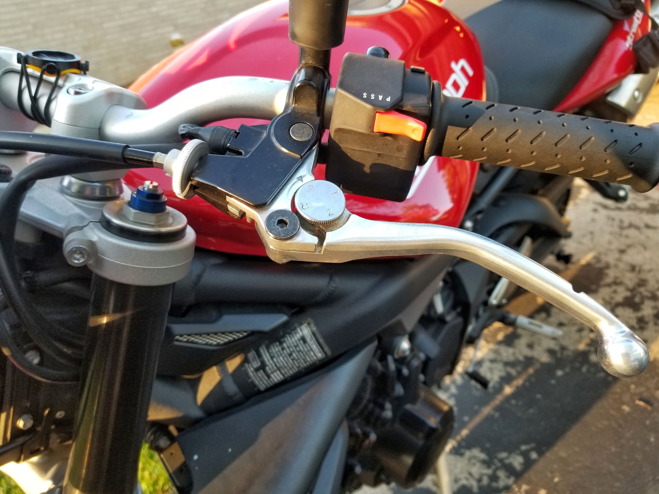 The clutch lever on a red 2012 Triumph Street Triple R