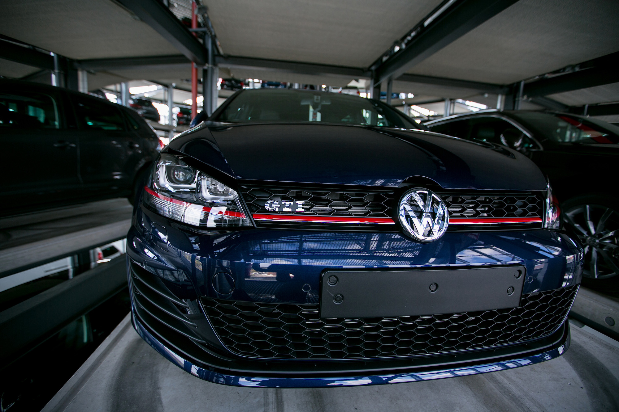 A dark-blue 2016 Volkswagen Golf GTI hatchback sits in a storage bay at a VW factory in Germany in April 2016