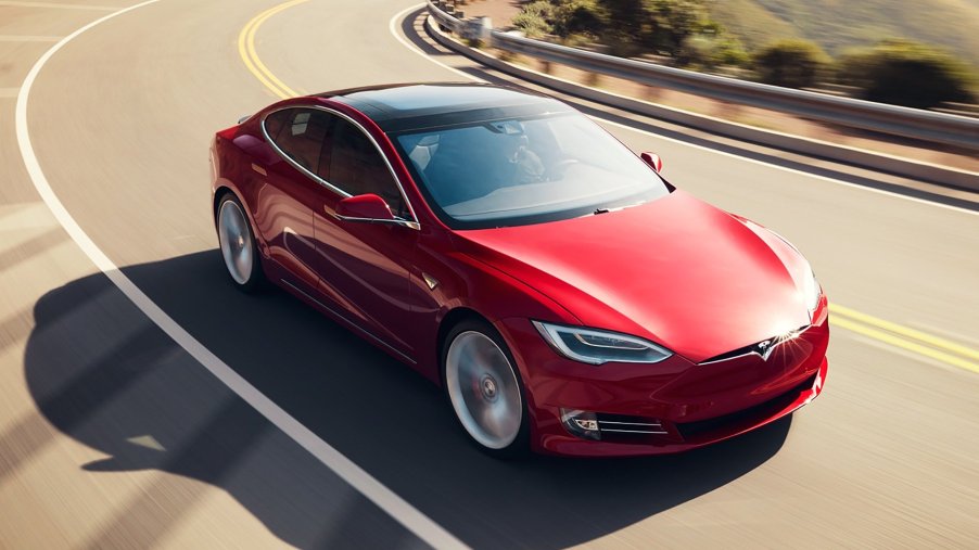 A red Tesla Model S on the open road