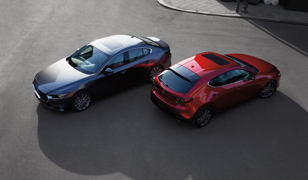 The overhead view of a gray 2020 Mazda 3 Sedan next to a red 2020 Mazda 3 Hatchback