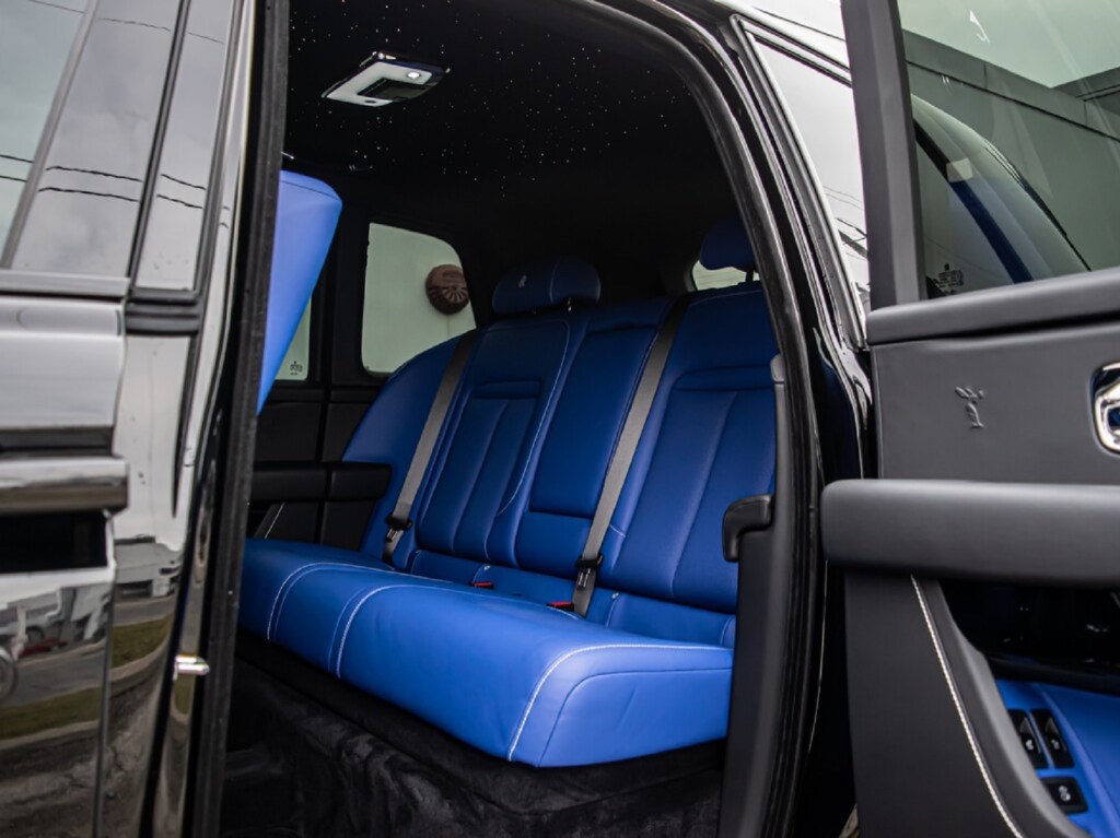 The blue-leather rear seats and Starliner headliner in a black 2020 Rolls-Royce Cullinan Black Badge