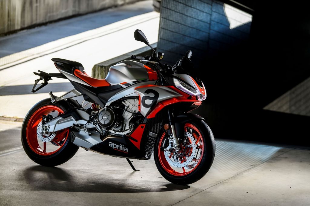A silver-black-and-red 2021 Aprilia RS 660 parked by a concrete ramp