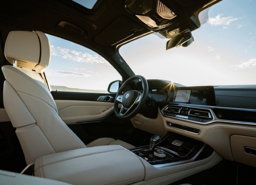 The tan-leather front seats and wood-trimmed dashboard of a 2021 BMW Alpina XB7