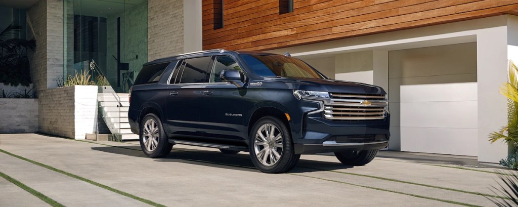 One of the safest large SUVs, a 2021 Chevy Suburban, sits outside of a house.