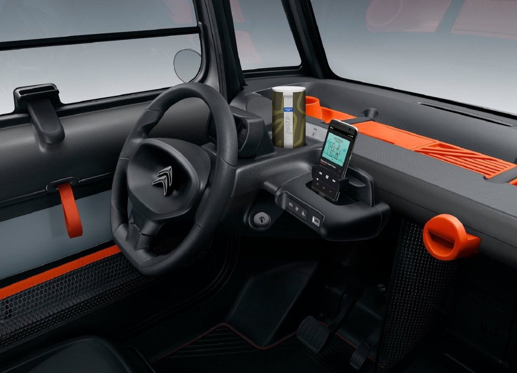 The black-and-orange dashboard and steering wheel of a 2021 Citroen Ami