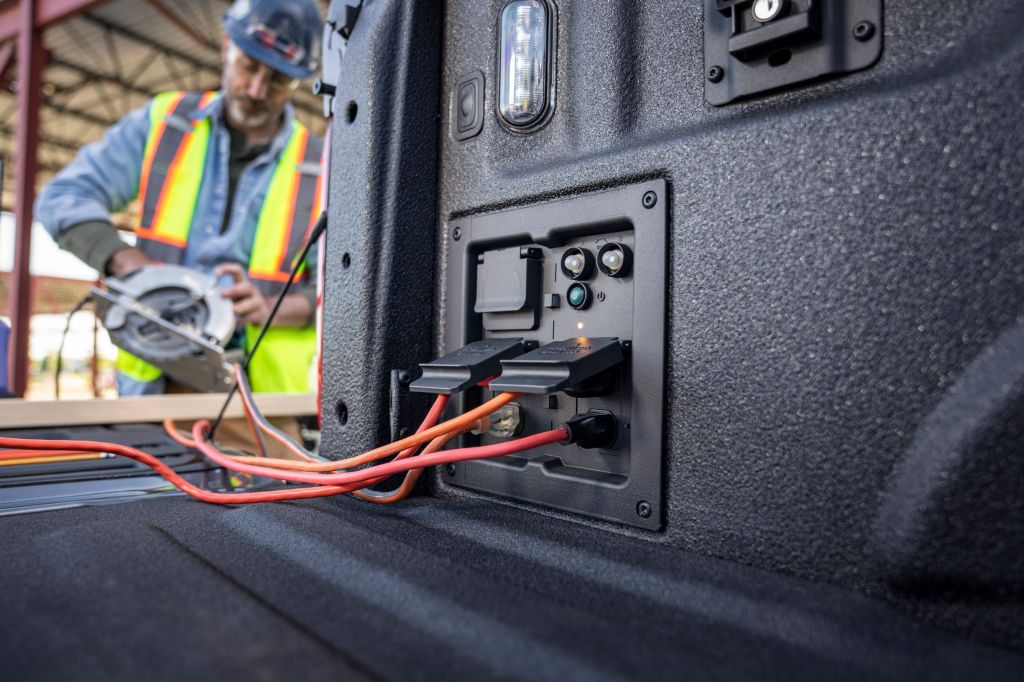 A construction worker using a saw plugged into the 2021 Ford F-150's Pro Power generator
