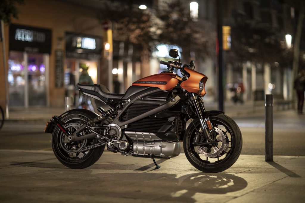 An orange-and-black 2021 Harley-Davidson LiveWire parked on a city street at night