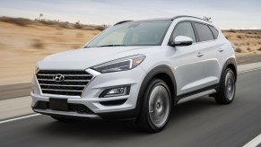 A white 2021 Hyundai Tucson compact crossover SUV traveling on a desert highway