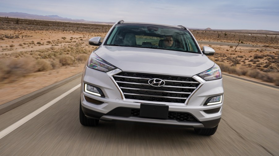 A white 2021 Hyundai Tucson compact crossover SUV traveling on a desert highway