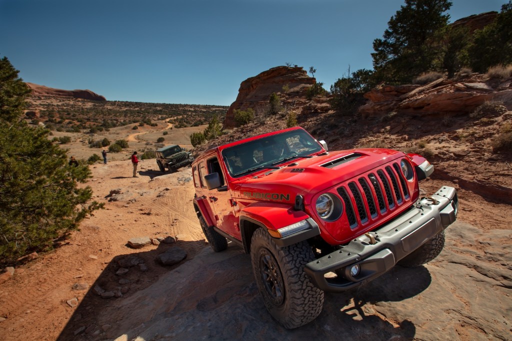 A red 2021 Jeep Wrangler Rubicon 392 SUV traveling on rocky terrain