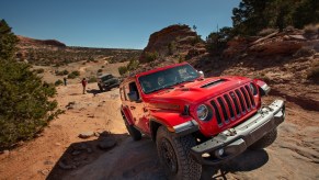 A red 2021 Jeep Wrangler Rubicon 392 SUV traveling on rocky terrain