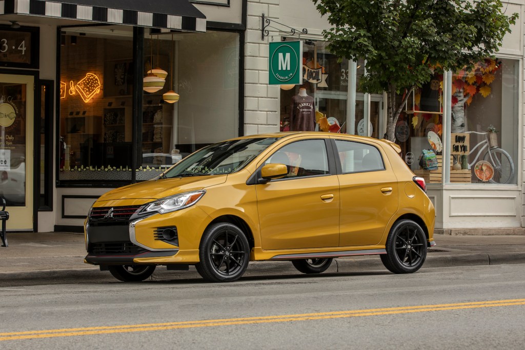 An orange 2021 Mitsubishi Mirage parked on a city street, one of the best affordable new cars under $20,000