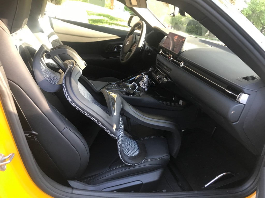 The top half of an office chair in the front seat of the Supra