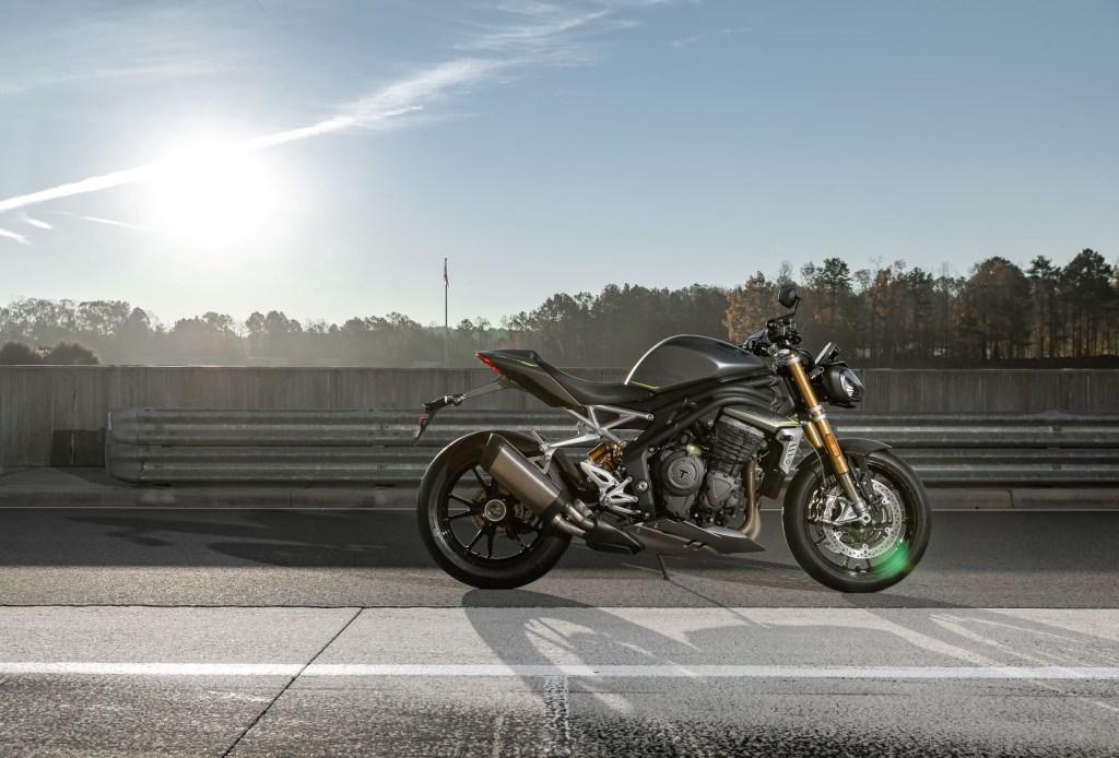 The side view of a gray-and-black 2021 Triumph Speed Triple 1200 RS on a racetrack
