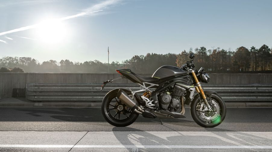 The side view of a gray-and-black 2021 Triumph Speed Triple 1200 RS on a racetrack