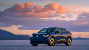 A blue 2021 Volkswagen ID.4 electric SUV parked in a desert at sunset
