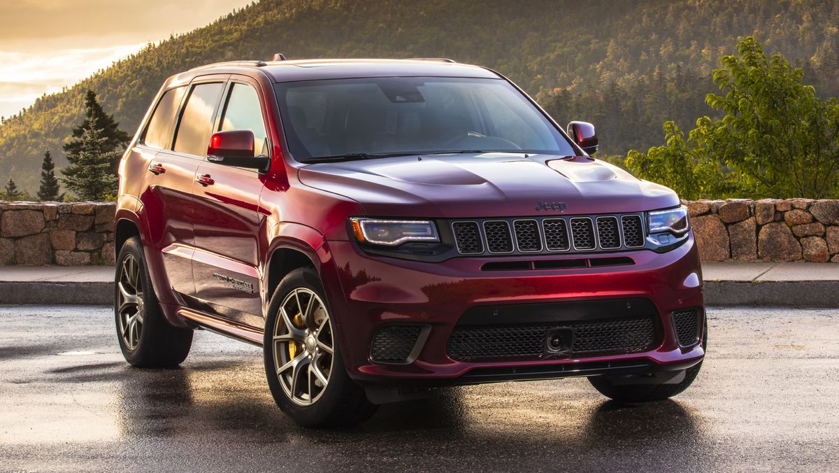 A red 2021 Jeep Grand Cherokee Trackhawk parked in front of the sunset