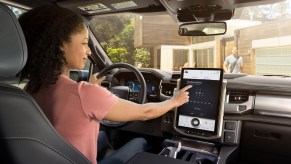 A woman sits in the driver's seat of 2022 Ford F-150 Lightning Lariat electric pickup truck
