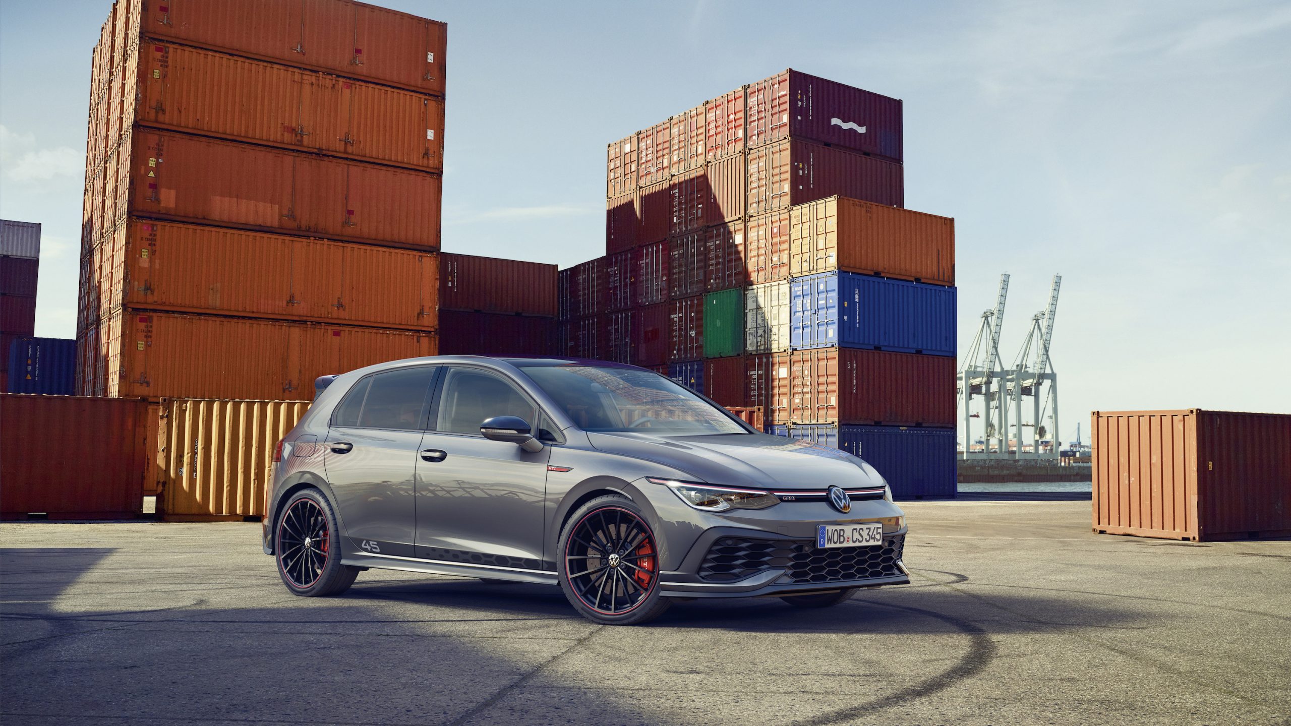 Silver 2022 Volkswagen Golf GTI Clubsport 45 sedan parked in front of shipping containers