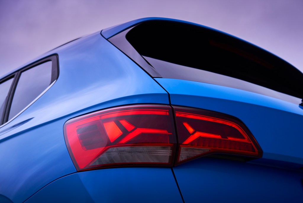 A rear driver's side view of a blue 2022 Volkswagen Taos SUV's taillight and back window
