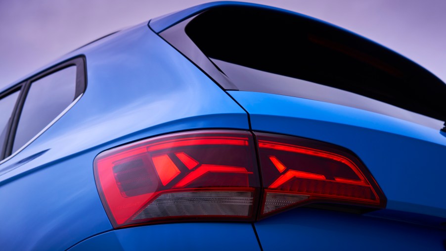 A rear driver's side view of a blue 2022 Volkswagen Taos SUV's taillight and back window