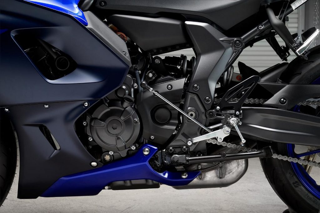 A close-up of the parallel-twin engine and rear frame of a blue-and-black 2022 Yamaha YZF-R7