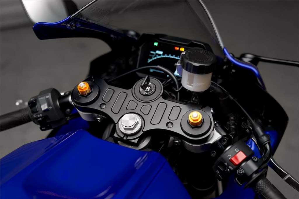 The clip-on bars and LCD dash of a blue 2022 Yamaha YZF-R7