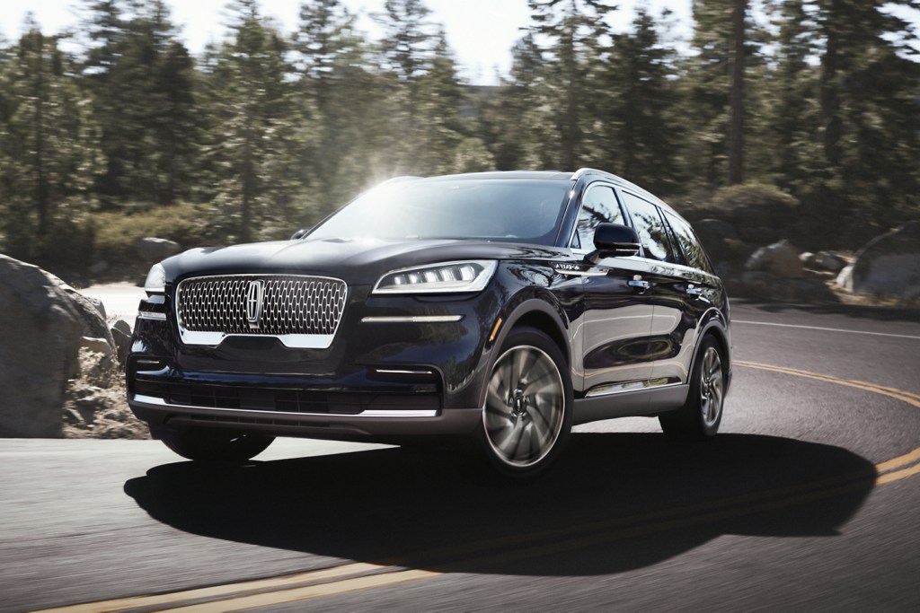 The 2021 Lincoln Aviator driving on a curvy road through the forest