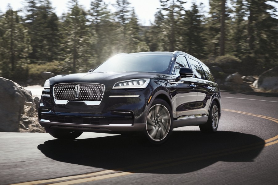 The 2021 Lincoln Aviator driving on a curvy road through the forest