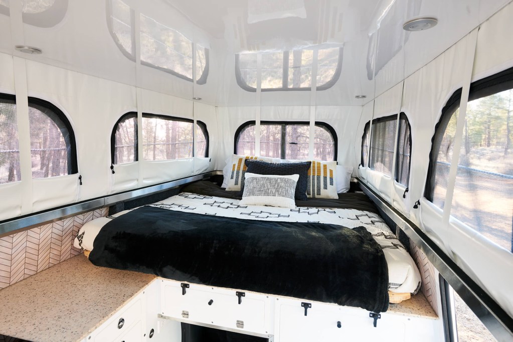an inviting bed in EarthCruiser's new picturesque 4x4 overland chalet interior