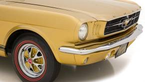 An image of a gold Ford Mustang parked inside of a photo studio.