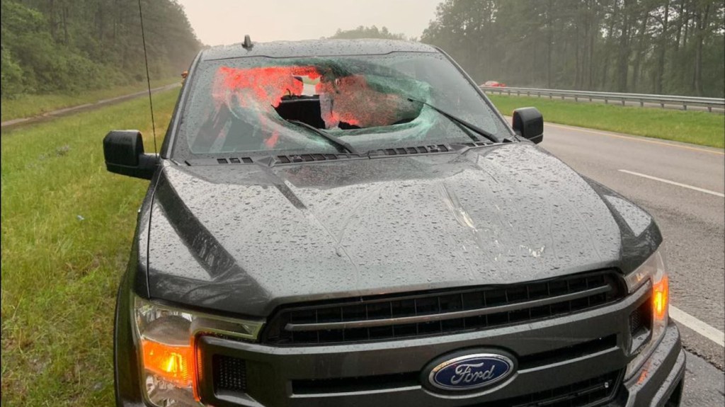 A Ford F-150 with a broken windshield by the side of the highway in Florida