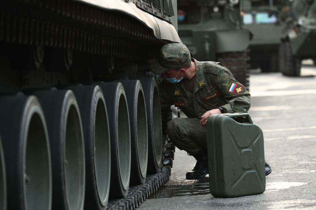 A Russian soldier refills a missile launcher via a 'jerry can' gas can