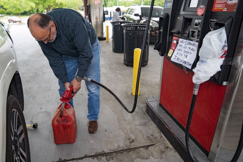 A motorist fills a red plastic gas can at an Atlanta, Georgia gas station