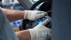 An employee assembles an airbag with a steering wheel