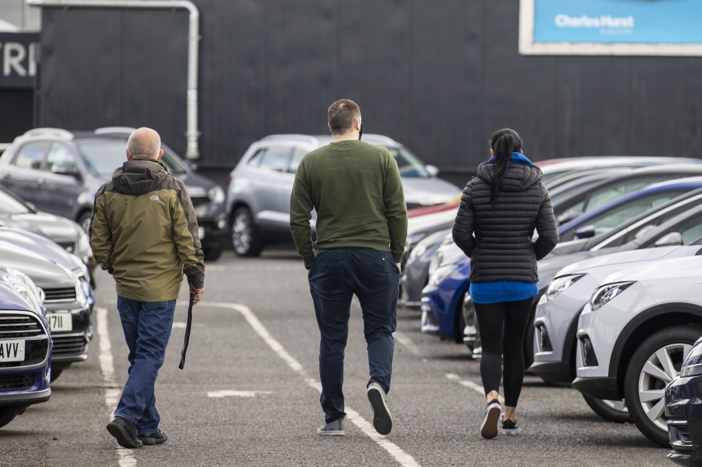 Potential car shoppers walk around Charles Hurst Usedirect used car dealership on Boucher Road